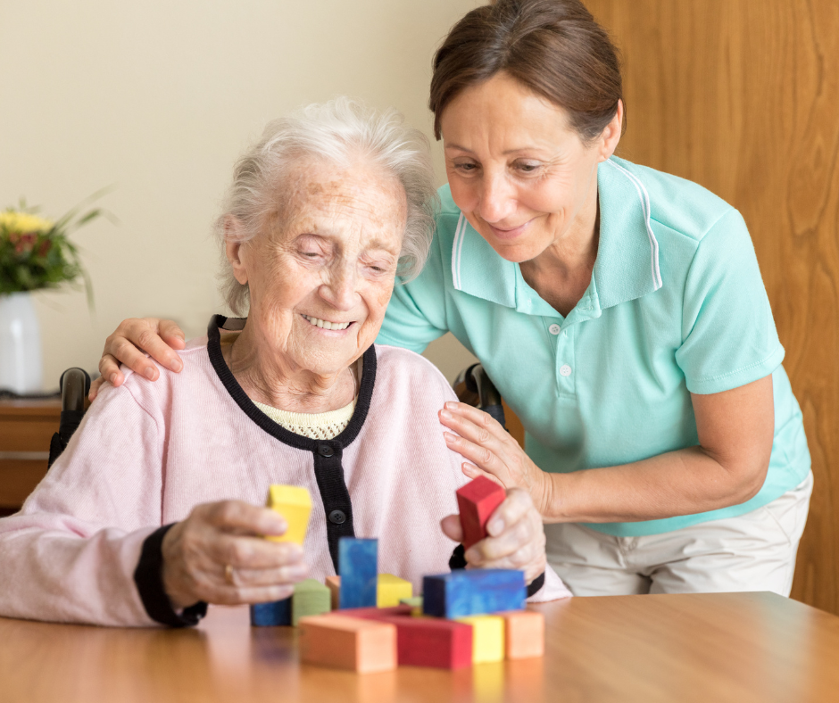 Pflegerin hilft einer Altenheimbewohnerin 